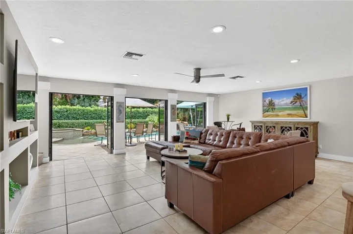 Living area with light tile patterned floors, recessed lighting, ceiling fan, and a textured ceiling