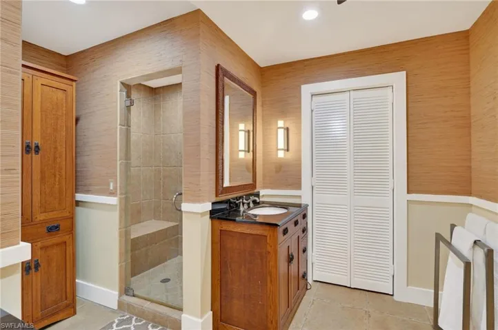 Full bath with a closet, a shower stall, and vanity