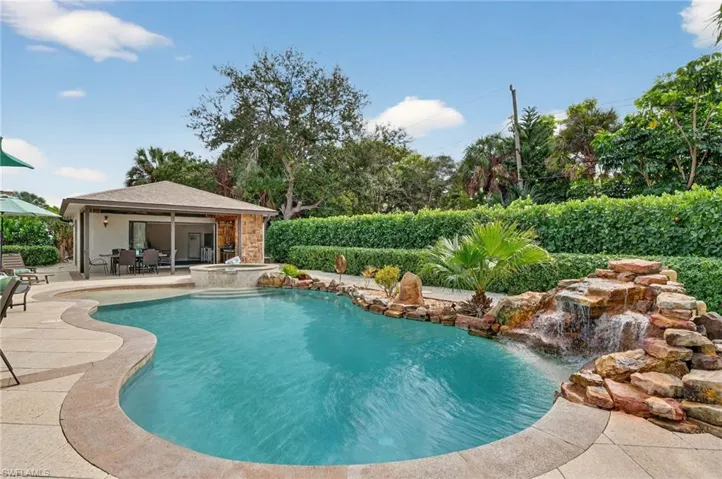 View of pool featuring a patio area, a pool with connected hot tub, and outdoor dining space