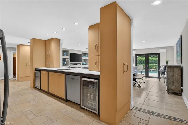 Kitchen featuring french doors, wine cooler, stainless steel dishwasher, recessed lighting, and light brown cabinetry