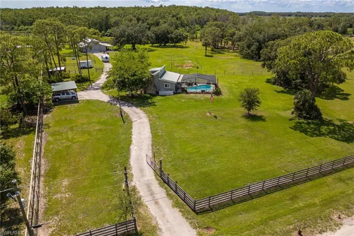 Aerial view of sparsely populated area featuring agricultural land and a heavily wooded area