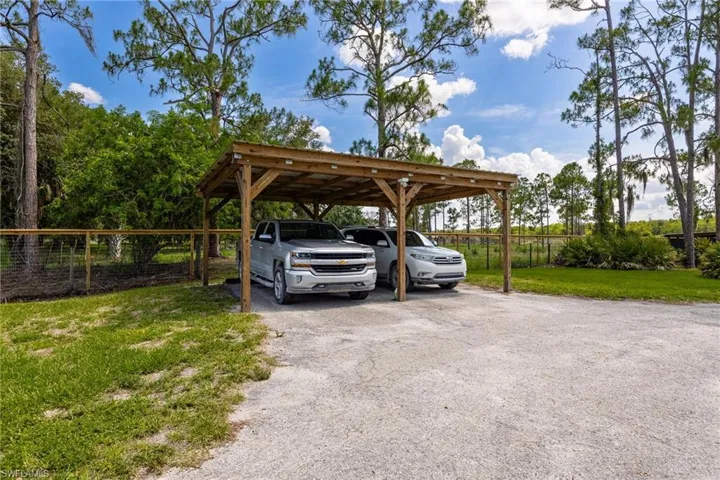 View of car parking with driveway and a detached carport
