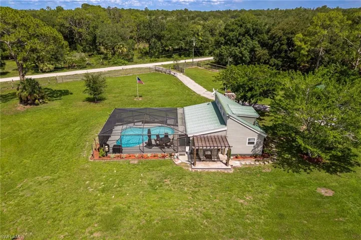 View of subject property with a forest and a pool area