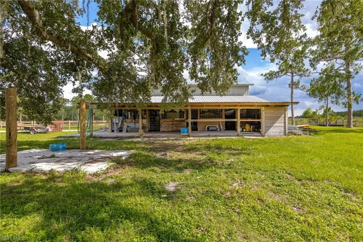 Rear view of house featuring an exterior structure, a metal roof, and an outbuilding