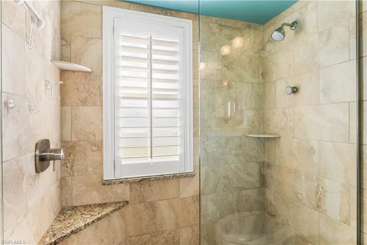 Master bath offers a walk in shower, seating, seamless glass enclosure.  Plantation shutters.
