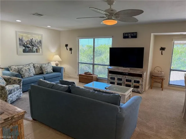 Living area with carpet floors, a ceiling fan, and recessed lighting