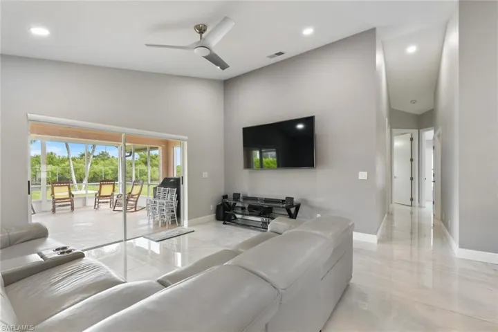 Living area with ceiling fan, recessed lighting, and a high ceiling