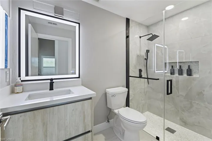 Full bathroom featuring vanity and a marble finish shower