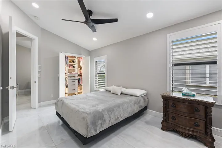 Bedroom with a spacious closet, vaulted ceiling, ceiling fan, and recessed lighting