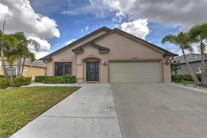 Ranch-style house featuring stucco siding, driveway, a front lawn, and an attached garage
