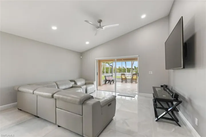 Living area with a ceiling fan, lofted ceiling, and recessed lighting