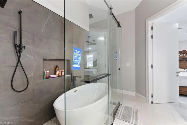 Full bathroom featuring ensuite bathroom, a shower stall, and a freestanding tub