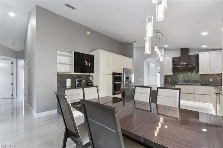 Dining space with recessed lighting and arched walkways
