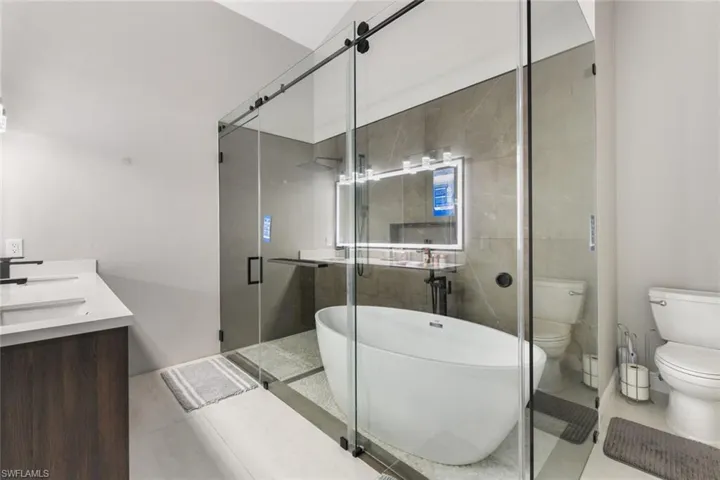Full bath with a shower stall, a soaking tub, and double vanity