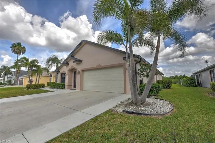 Ranch-style home featuring stucco siding, a front lawn, driveway, and a garage