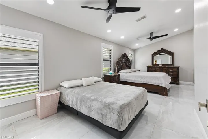Bedroom featuring ceiling fan, recessed lighting, and light marble finish flooring