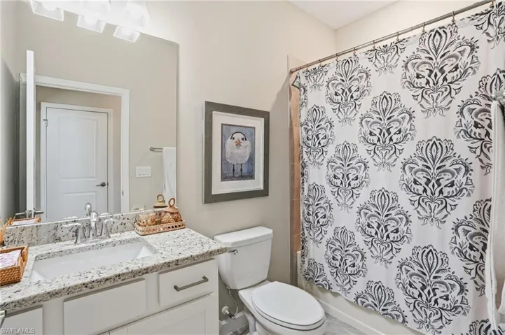Bathroom featuring shower / bath combo with shower curtain and vanity