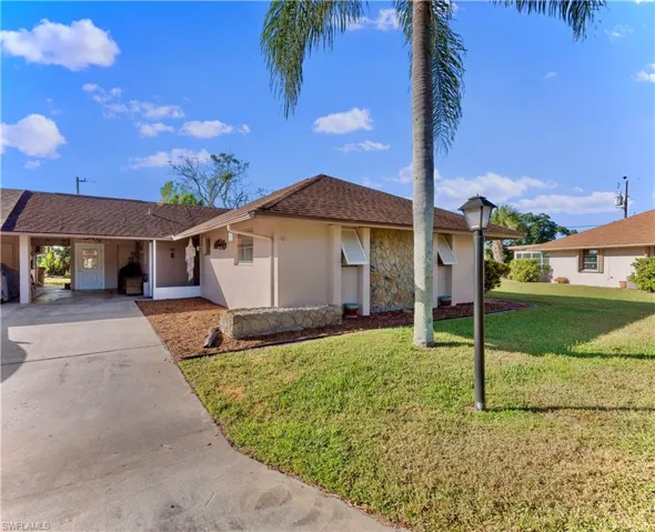 Single story home featuring a carport and a front lawn