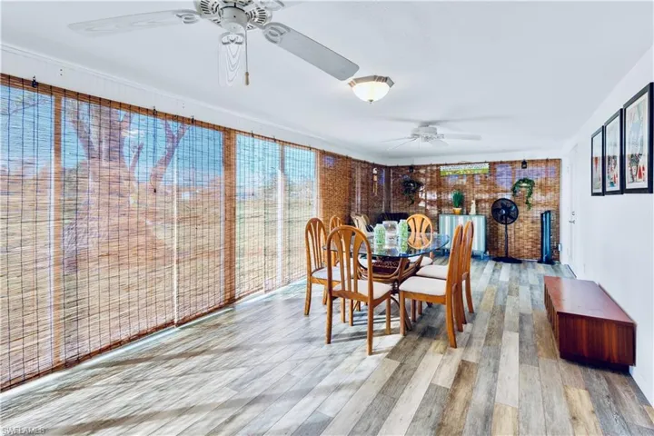 Dining area featuring ceiling fan, brick wall, and light hardwood / wood-style flooring