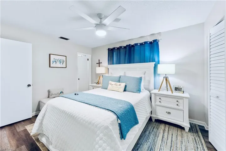 Bedroom with dark hardwood / wood-style flooring, a closet, and ceiling fan