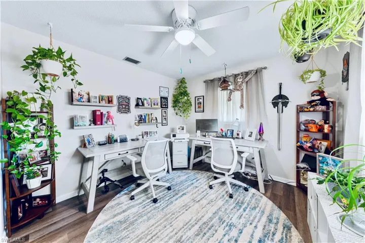 Office area with a textured ceiling, dark hardwood / wood-style floors, and ceiling fan