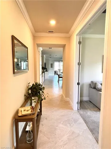 Hall featuring ornamental molding and baseboards