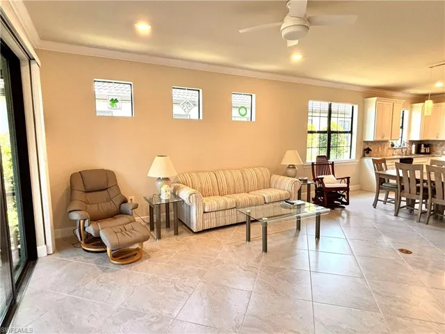Living room with ornamental molding and ceiling fan