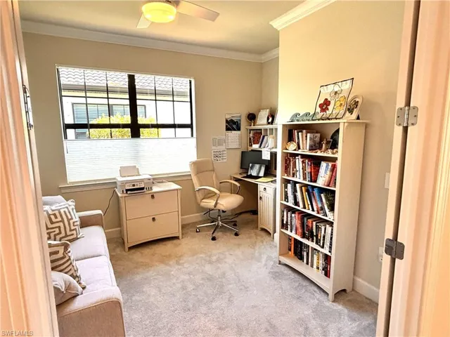 Office space featuring ornamental molding, light carpet, and a ceiling fan