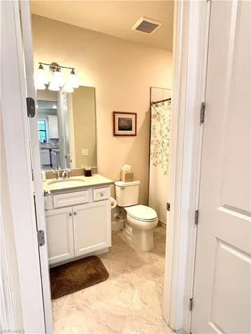Bathroom featuring a shower with shower curtain and vanity