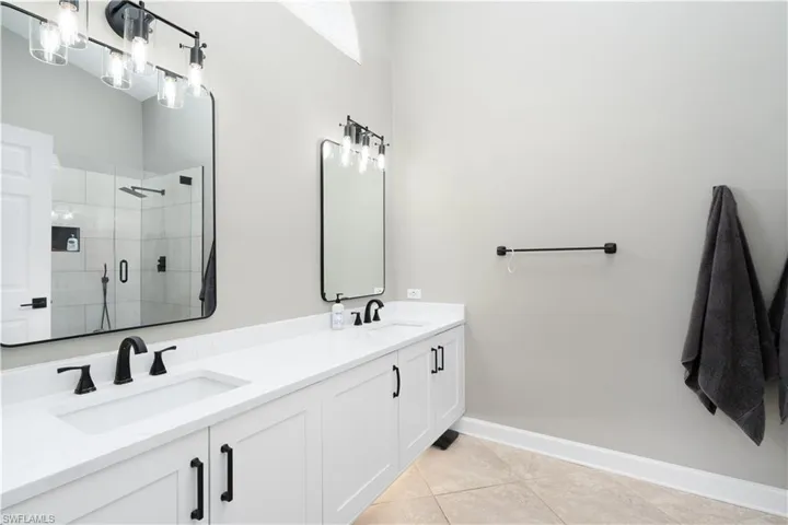 En-suite primary bathroom. Upgraded by previous owner in 2024. Two separate sinks, newer faucets/fixtures and one huge shower stall along with raised and floating cabinetry.