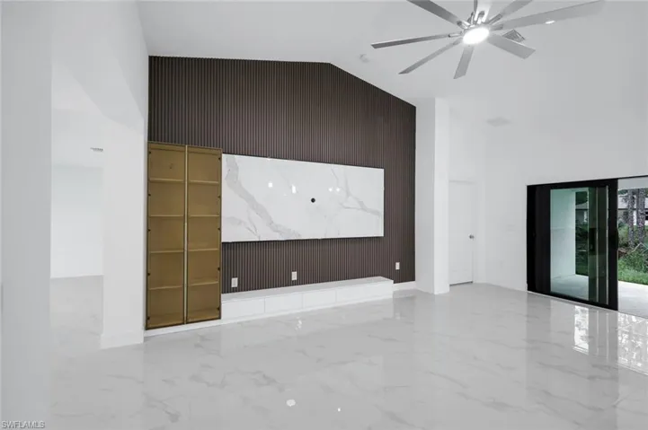 Great room accent wall ready for your a larger TV walls, , high vaulted ceiling, marble tiled floors, and ceiling fan