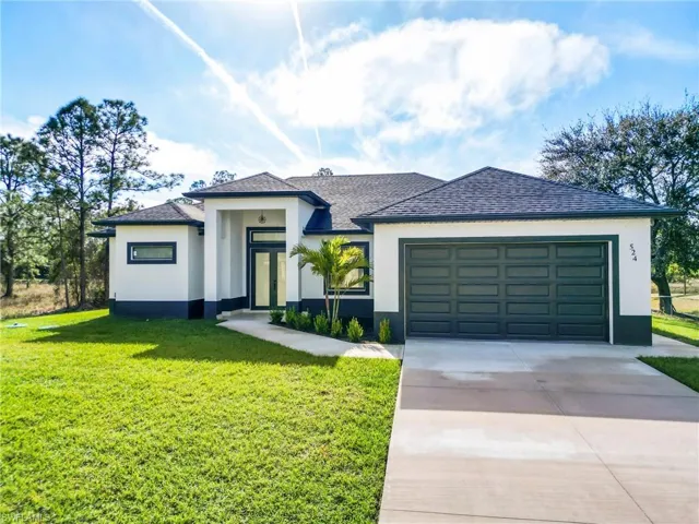 View of front of home with a front yard and a garage