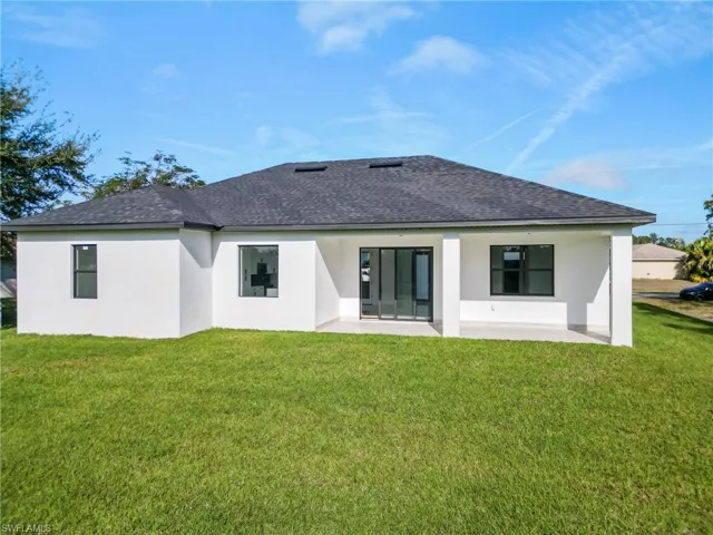 Rear view of house with a patio area and a yard