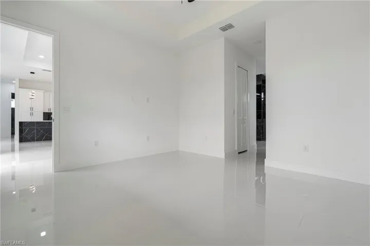 Unfurnished room with a tray ceiling and tile patterned floors