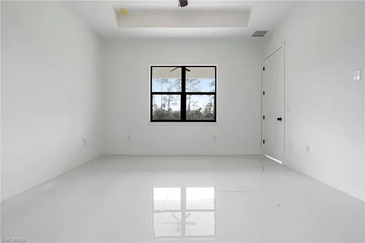 Spare room with a raised ceiling and light tile patterned flooring