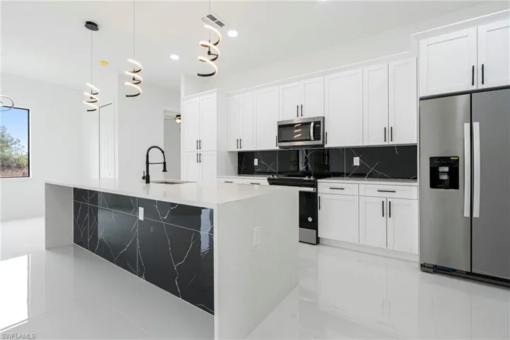 Kitchen featuring white cabinets, sink, and stainless steel appliances