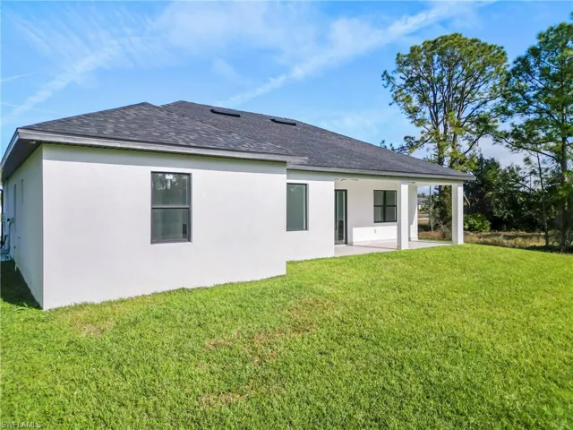 Back of property with a yard and a patio