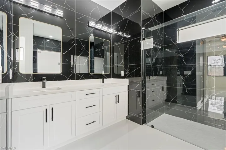 Bathroom featuring a tile shower and vanity