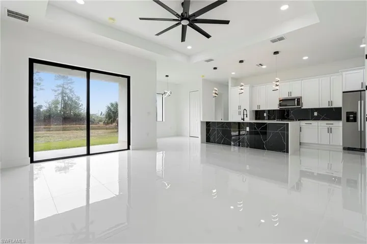 Kitchen with white cabinets, appliances with stainless steel finishes, and a tray ceiling