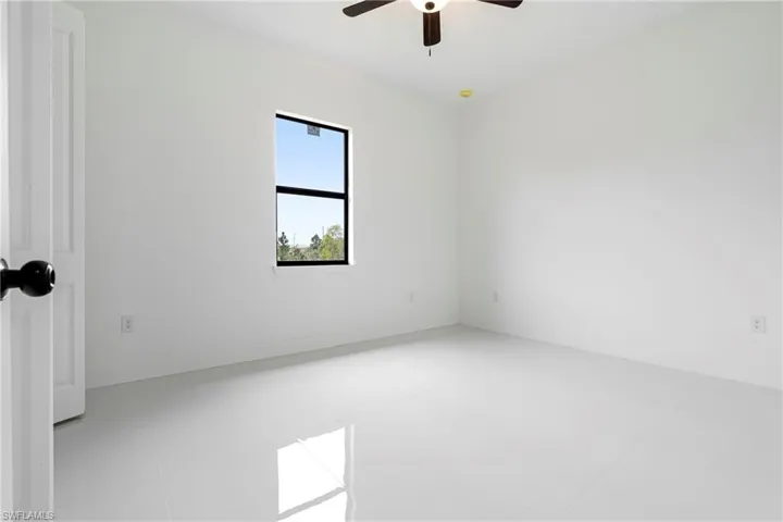 Unfurnished room featuring light tile patterned floors and ceiling fan