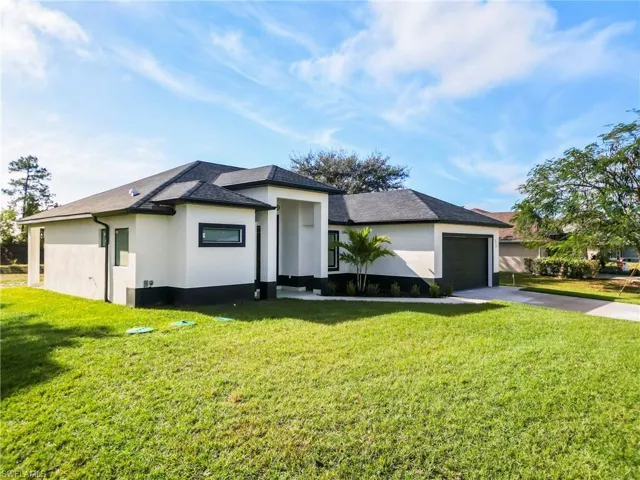View of front of house featuring a garage and a front lawn