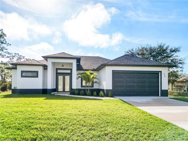View of front facade featuring a garage and a front yard