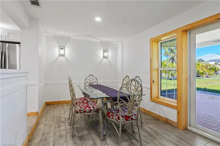 Dining room with recessed lighting, visible vents, light wood-style flooring, and wainscoting