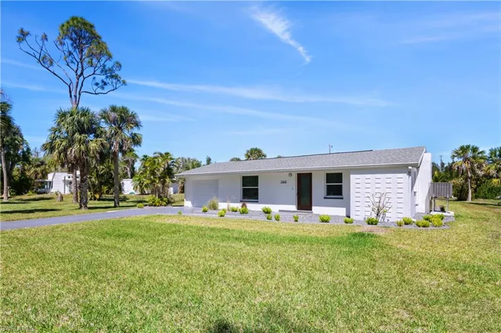 Ranch-style home with aphalt driveway, a front lawn, and a garage