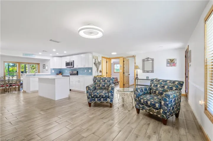 Living area with recessed lighting, light wood-style floors, visible vents, and baseboards