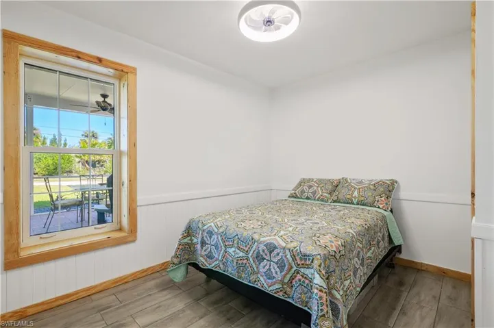 Bedroom featuring wainscoting and wood tiled floor