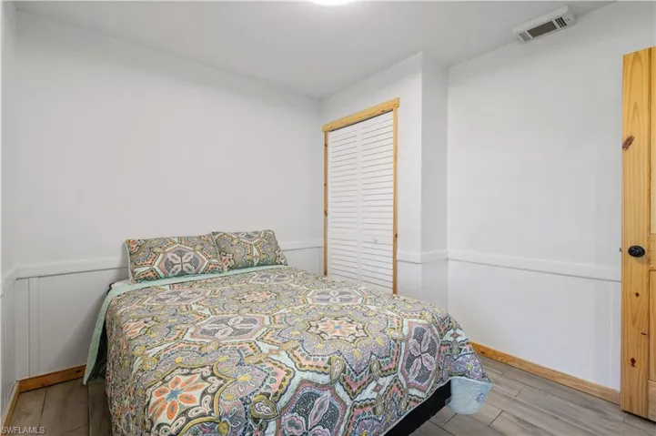Bedroom featuring a closet, visible vents, and wood finished floors