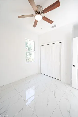 Unfurnished bedroom featuring a closet, a ceiling fan, and light marble finish flooring. Photos are of a staged model or similar plan. Features and finishes may vary.