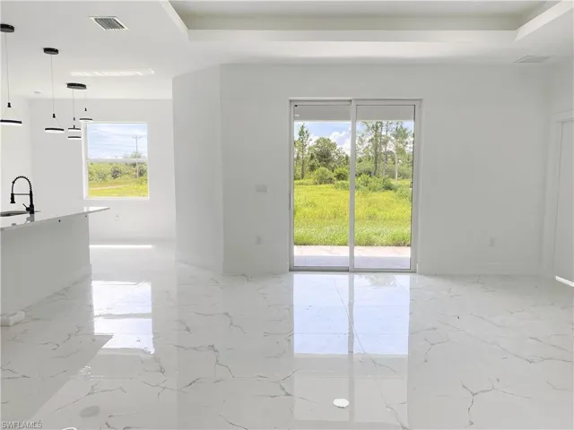 Empty room featuring light marble finish flooring and a raised ceiling. Photos are of a staged model or similar plan. Features and finishes may vary.