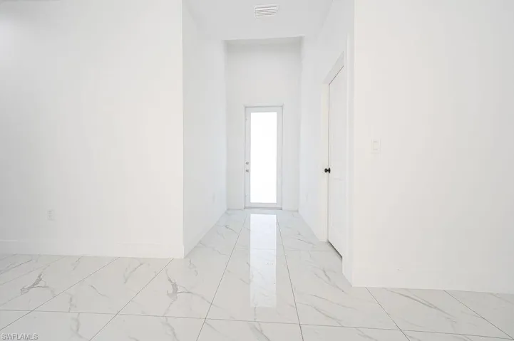 Corridor with light marble finish flooring and baseboards. Photos are of a staged model or similar plan. Features and finishes may vary.